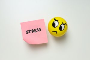 Paper with word Stress and ball on white background, top view