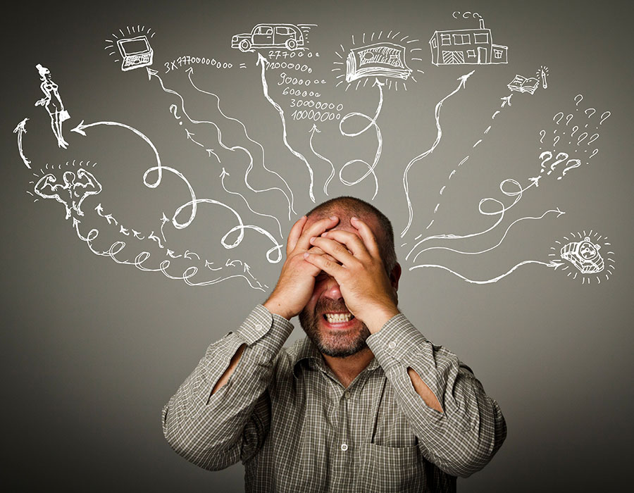Stressed man holding his head with different thought images swirling around him