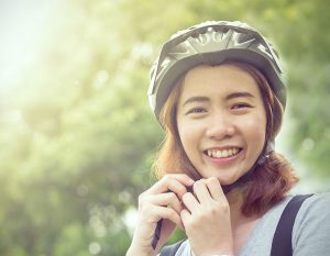 Young lady putting on a bike helmet for Active Transportation