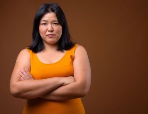Middle aged woman with her arms folded looking into the camera