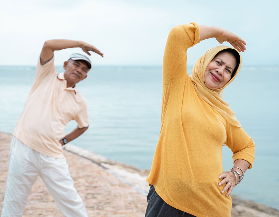 A couple stretching at the beach in the summer
